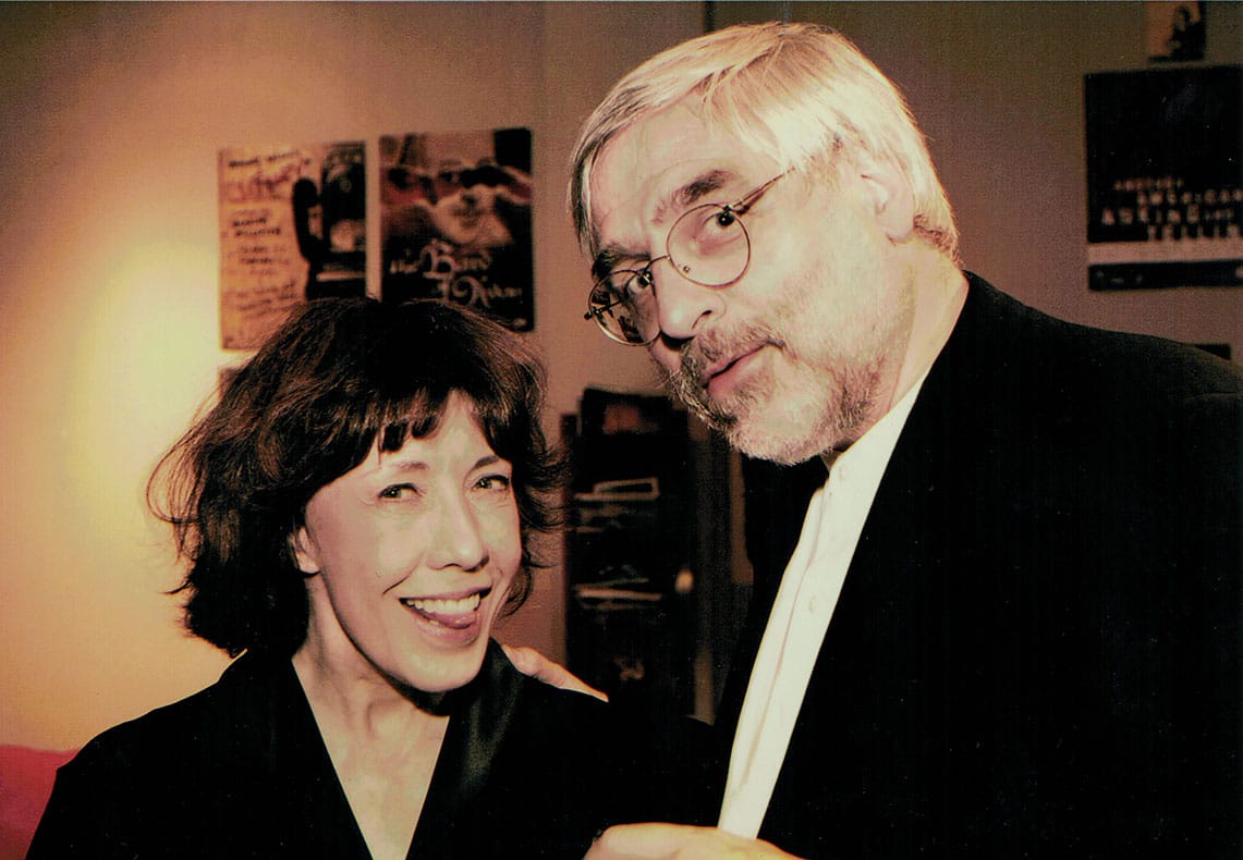 A smiling Lily Tomlin stands with Bruce Johnson